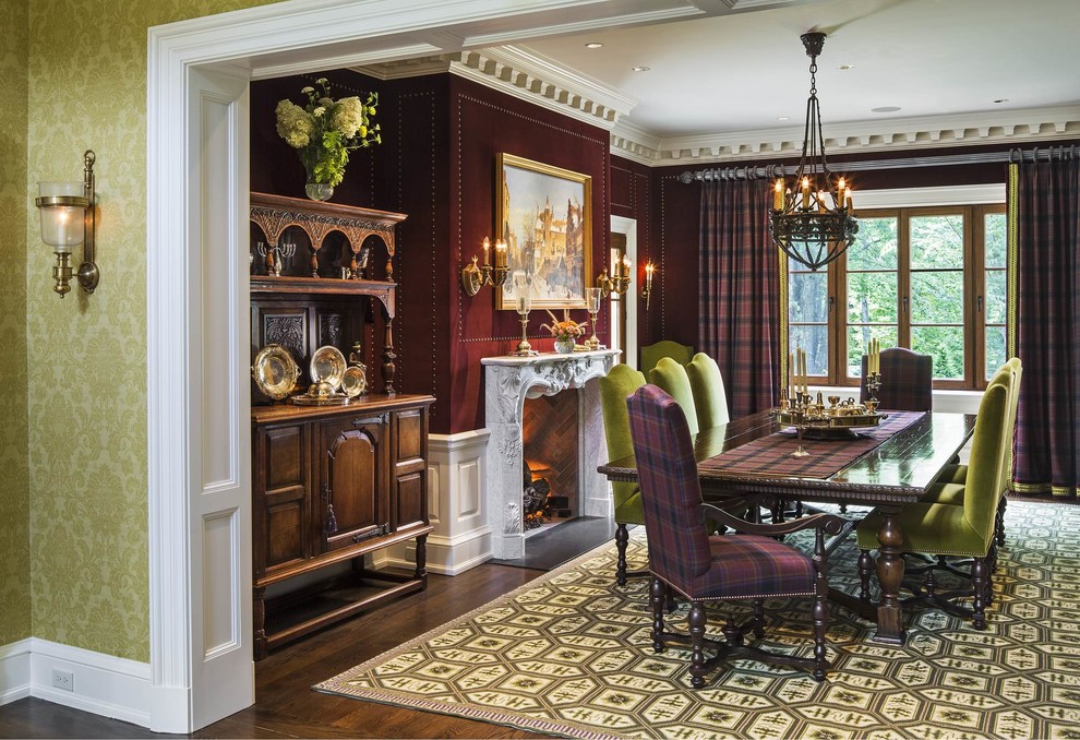 Idées déco pour une salle à manger victorienne fermée et de taille moyenne avec un mur rouge, parquet foncé, une cheminée standard, un manteau de cheminée en pierre et un sol marron.