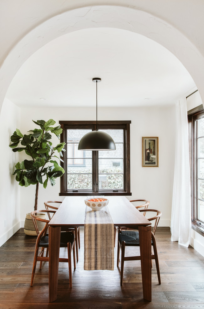 Idee per una sala da pranzo aperta verso la cucina minimal con pareti bianche, parquet scuro e pavimento marrone