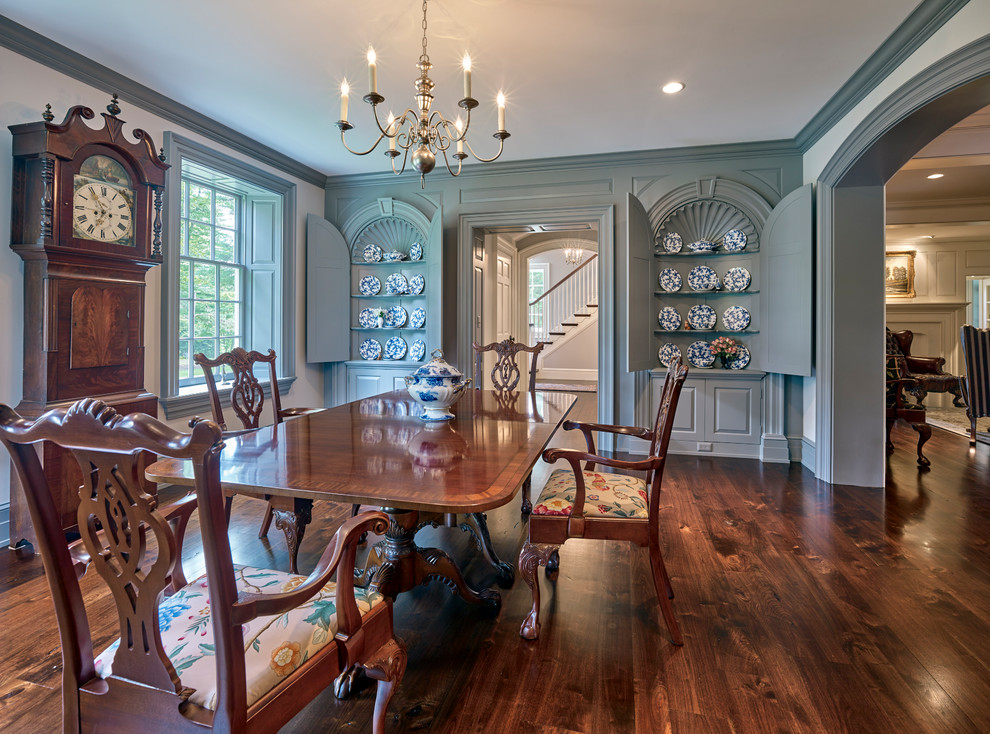 Aménagement d'une salle à manger ouverte sur la cuisine classique de taille moyenne avec un mur bleu, parquet foncé, une cheminée standard, un manteau de cheminée en bois et un sol marron.