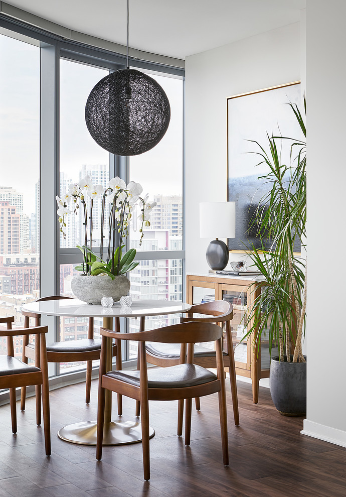 Inspiration pour une salle à manger design avec un mur blanc, parquet foncé et un sol marron.