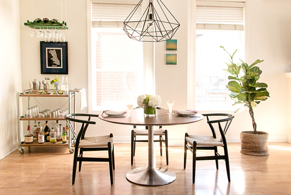 Cette image montre une salle à manger ouverte sur la cuisine minimaliste de taille moyenne avec un mur gris, parquet clair, aucune cheminée et un sol marron.