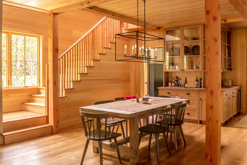 Idées déco pour une salle à manger ouverte sur la cuisine montagne avec un sol en bois brun et un sol marron.