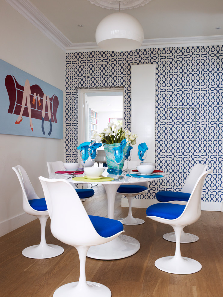 Inspiration for a small contemporary medium tone wood floor enclosed dining room remodel in London with multicolored walls
