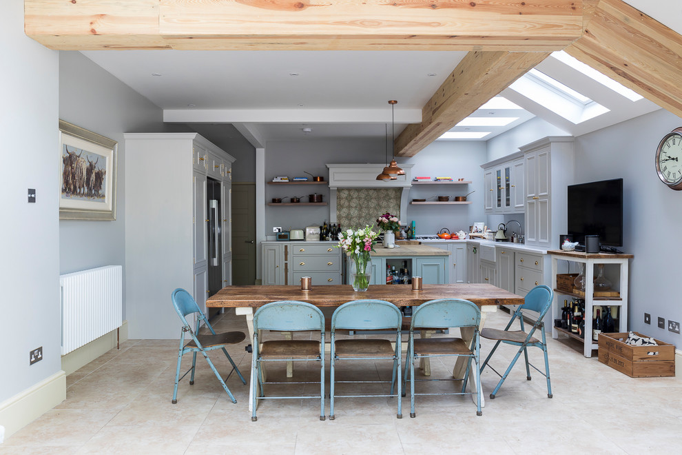 Foto di una sala da pranzo aperta verso la cucina country di medie dimensioni con pavimento in pietra calcarea, pavimento beige e pareti grigie