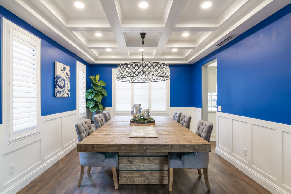 Immagine di una sala da pranzo aperta verso la cucina tradizionale di medie dimensioni con pareti blu, pavimento in vinile e pavimento marrone