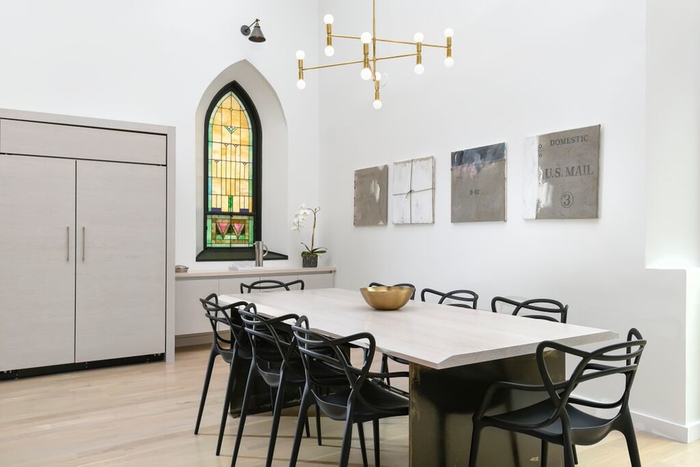 Imagen de comedor contemporáneo abierto con paredes blancas y suelo de madera clara