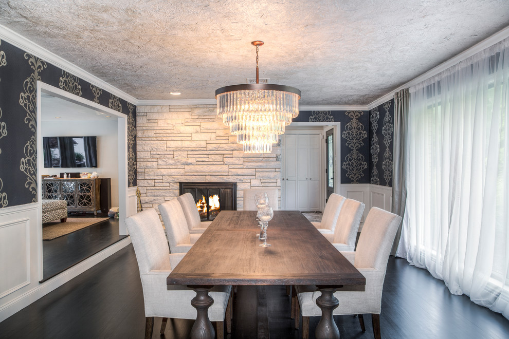 Inspiration pour une grande salle à manger design fermée avec un mur gris, parquet foncé, un manteau de cheminée en pierre, une cheminée standard et un sol marron.