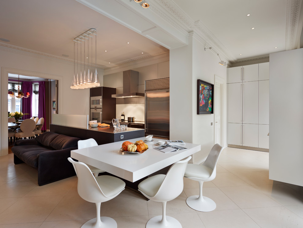 Immagine di una sala da pranzo aperta verso la cucina minimal con pareti bianche e pavimento beige