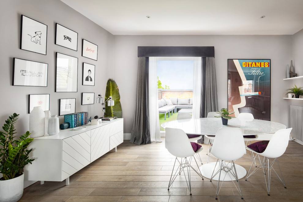 Modernes Esszimmer mit grauer Wandfarbe, hellem Holzboden und braunem Boden in Hampshire