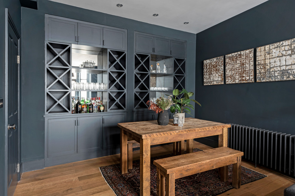 Esempio di una sala da pranzo contemporanea con pareti blu, pavimento in legno massello medio e pavimento marrone