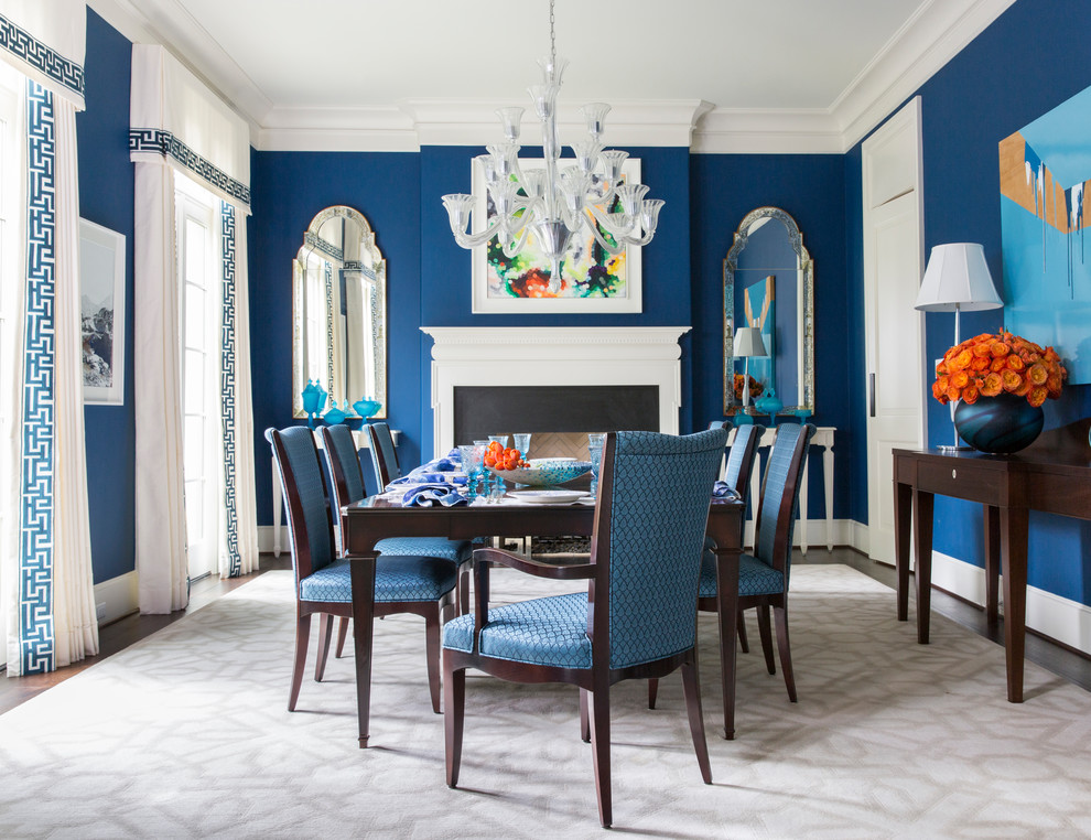 Cette image montre une rideau de salle à manger traditionnelle fermée avec un mur bleu, parquet foncé et une cheminée standard.