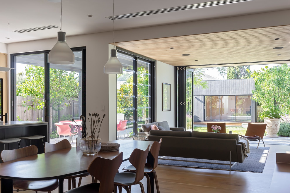 Свежая идея для дизайна: кухня-столовая в современном стиле с белыми стенами и светлым паркетным полом - отличное фото интерьера