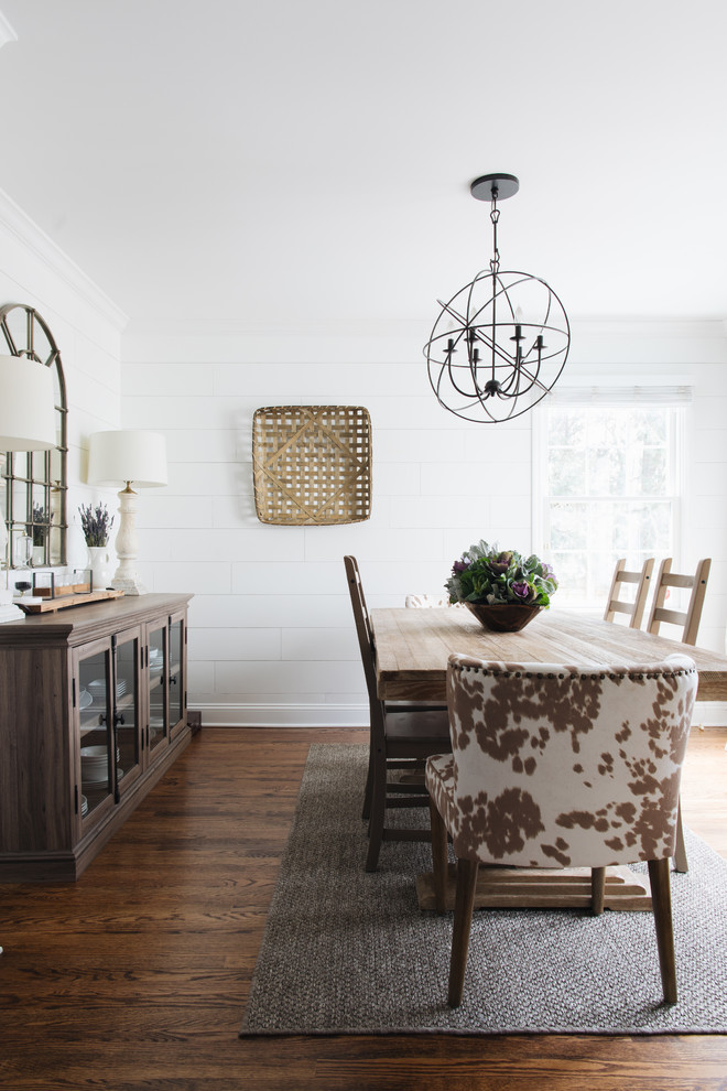 Imagen de comedor campestre con paredes blancas, suelo de madera en tonos medios y suelo marrón
