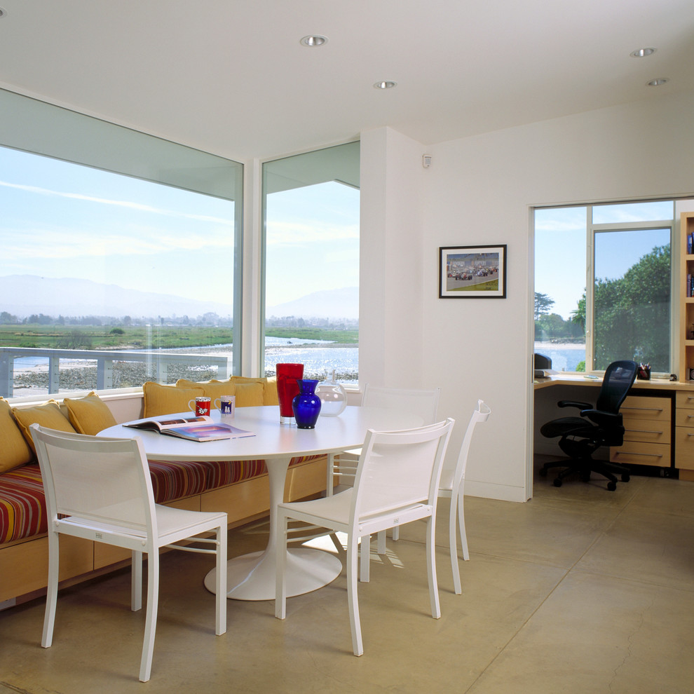 Coastal dining room in Santa Barbara with concrete flooring.