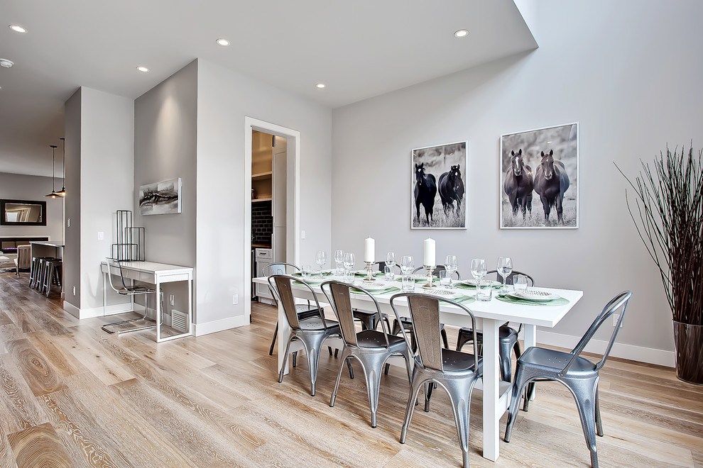 Diseño de comedor clásico renovado abierto con paredes grises y suelo de madera clara