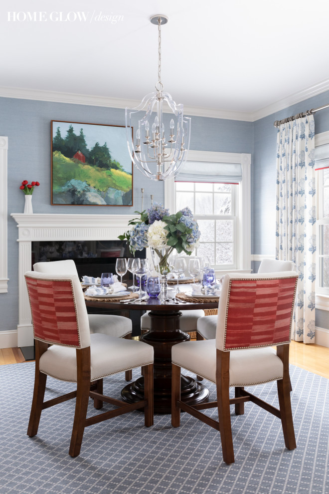 Immagine di una sala da pranzo classica chiusa e di medie dimensioni con pareti blu, camino classico e carta da parati