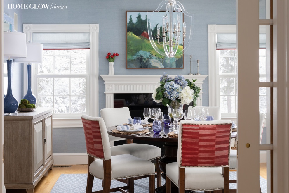 Exemple d'une salle à manger chic fermée et de taille moyenne avec un mur bleu, une cheminée standard et du papier peint.