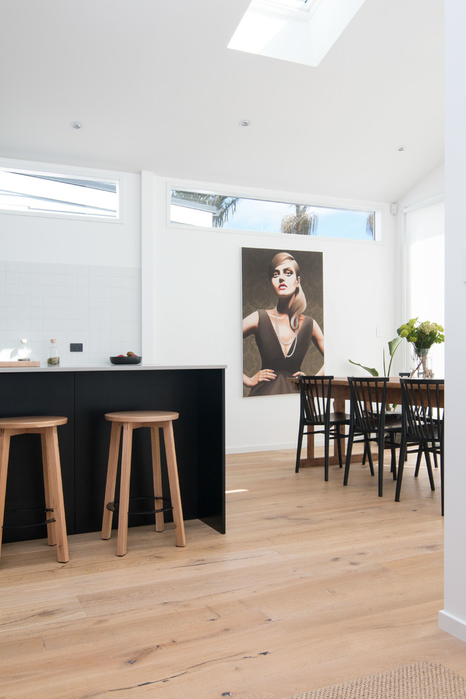 Immagine di una sala da pranzo aperta verso la cucina minimal di medie dimensioni con parquet chiaro, pavimento beige, pareti bianche e nessun camino