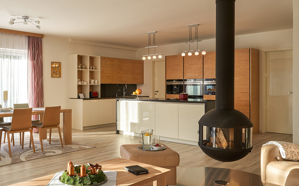 Cette photo montre une salle à manger ouverte sur la cuisine tendance de taille moyenne avec un mur blanc, un sol en contreplaqué, cheminée suspendue et un sol marron.