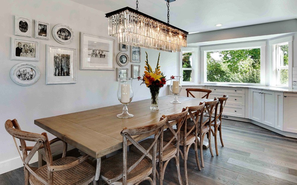 Cette image montre une salle à manger ouverte sur la cuisine traditionnelle de taille moyenne avec un mur blanc et un sol en bois brun.