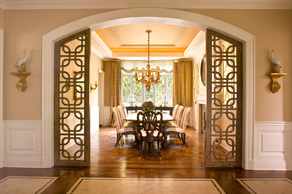 Imagen de comedor clásico cerrado con paredes beige, suelo de madera oscura y cortinas