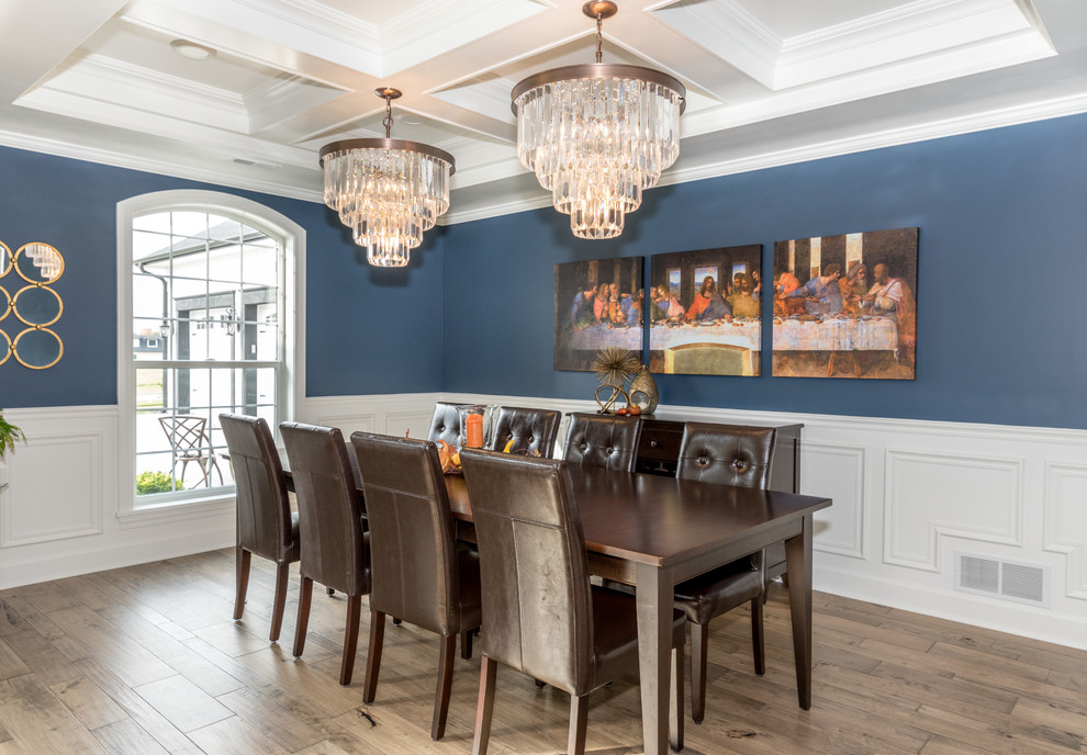 Ispirazione per una sala da pranzo chic con pareti blu, pavimento in legno massello medio e pavimento marrone