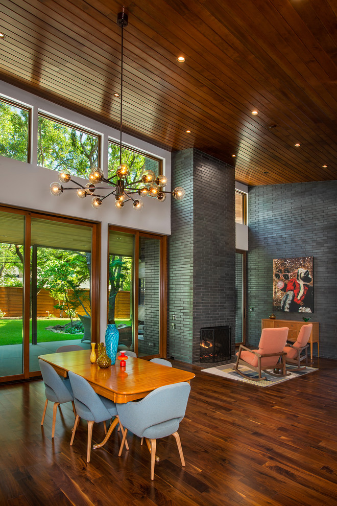 Inspiration for a mid-sized 1950s medium tone wood floor and brown floor great room remodel in Dallas with white walls, a standard fireplace and a brick fireplace