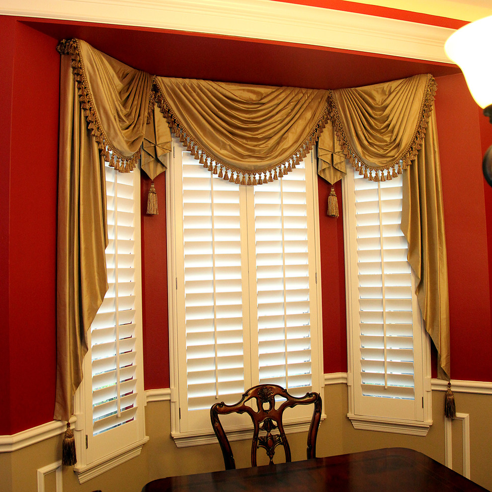 Aménagement d'une salle à manger classique avec un mur rouge.