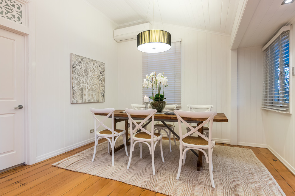 Immagine di una sala da pranzo stile marinaro chiusa con pareti bianche, pavimento in legno massello medio e pavimento beige