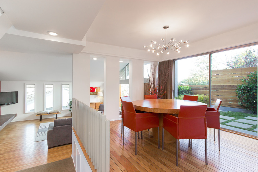 Immagine di una sala da pranzo minimalista con pareti bianche e pavimento in legno massello medio