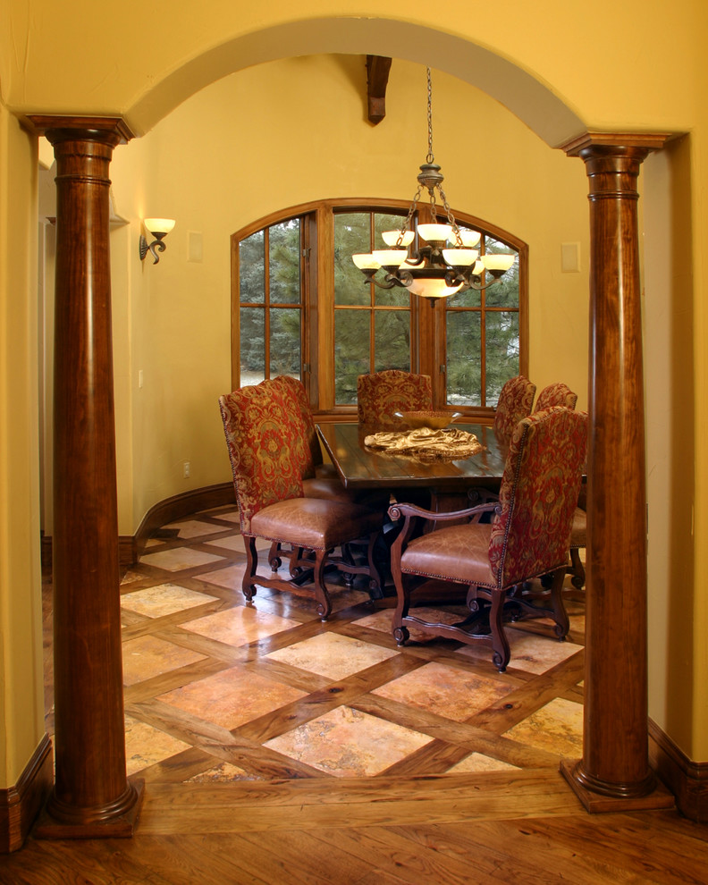На фото: отдельная столовая среднего размера в классическом стиле с желтыми стенами и полом из травертина