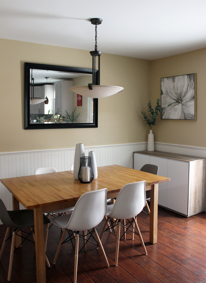 На фото: кухня-столовая среднего размера в современном стиле с желтыми стенами, полом из ламината и коричневым полом без камина