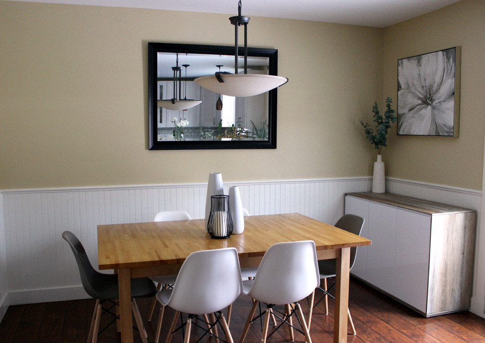 Mittelgroße Moderne Wohnküche ohne Kamin mit gelber Wandfarbe, Laminat und braunem Boden in Calgary