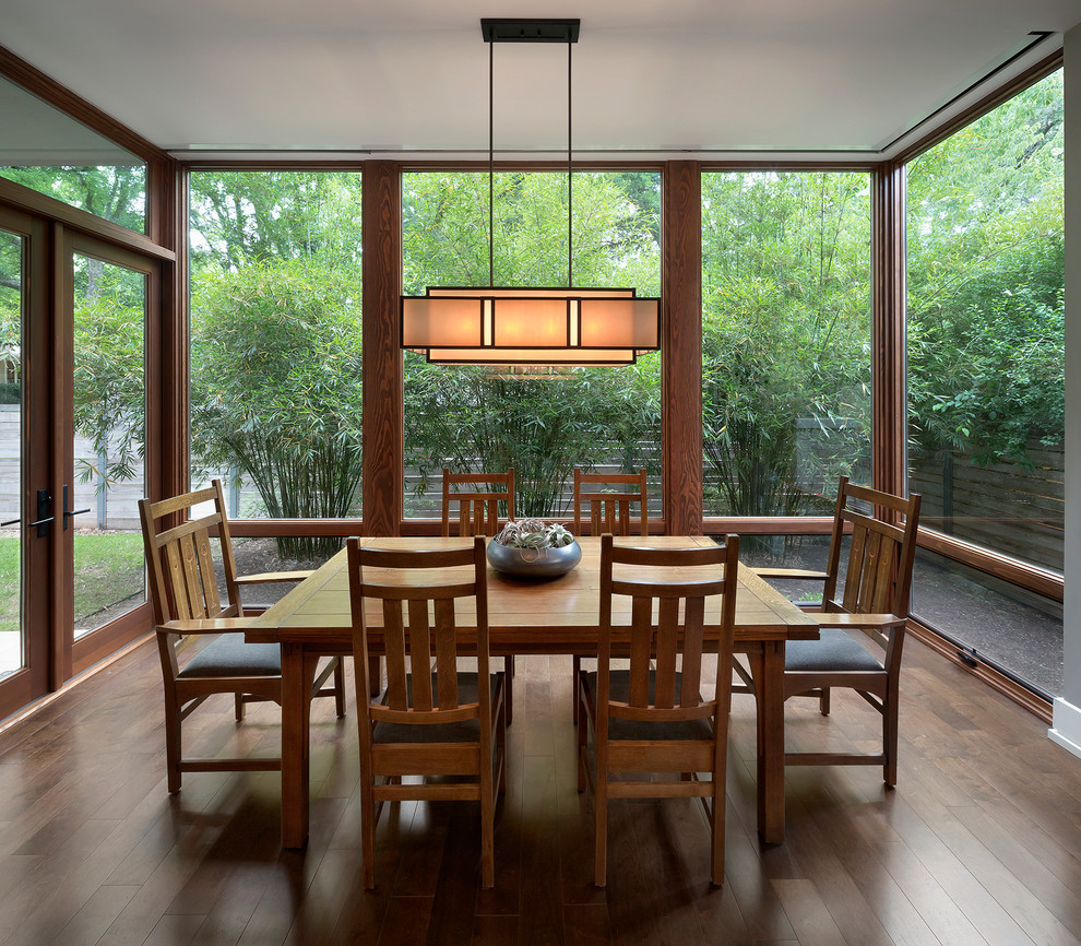 Aménagement d'une salle à manger craftsman fermée avec parquet foncé.