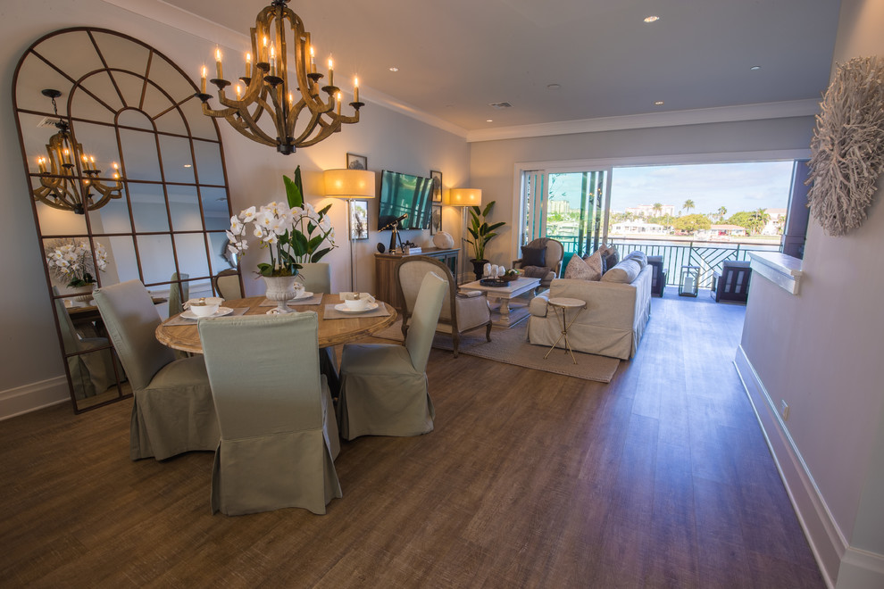 Exemple d'une salle à manger ouverte sur le salon chic de taille moyenne avec un mur beige, un sol en bois brun et éclairage.
