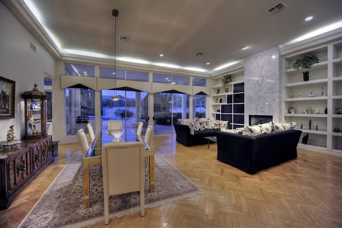 Photo of an expansive contemporary kitchen/dining room in Phoenix with beige walls, porcelain flooring, a standard fireplace and a stone fireplace surround.