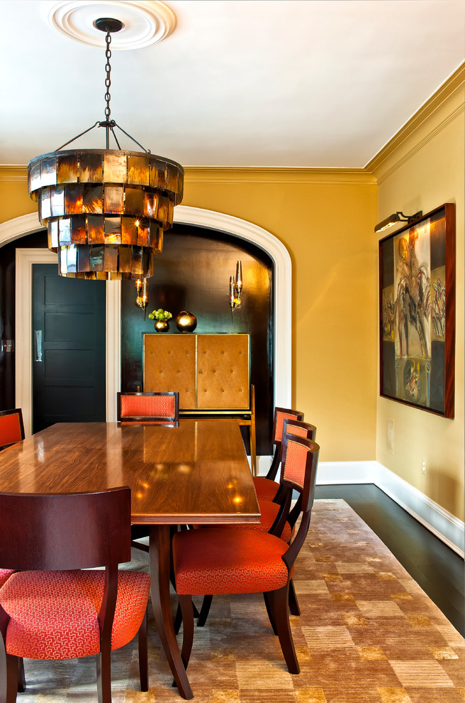 Foto de comedor contemporáneo con paredes amarillas y suelo de madera oscura