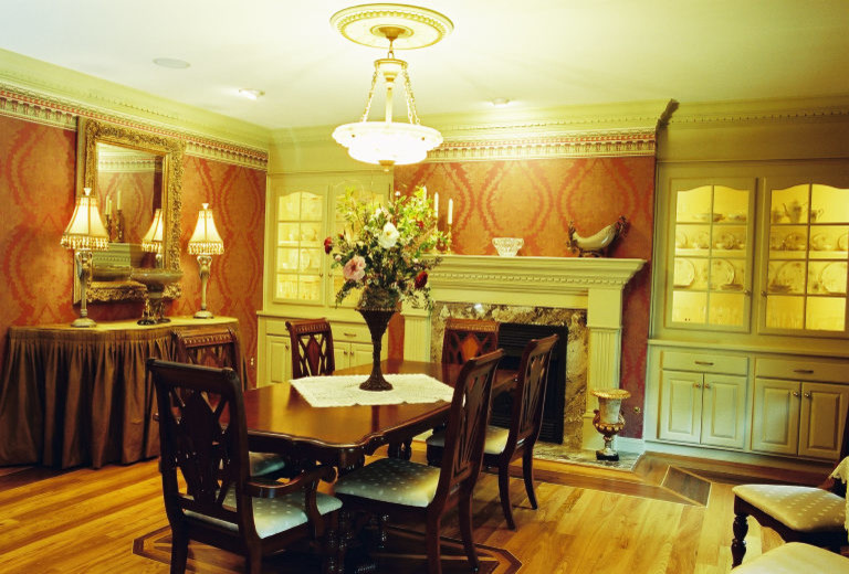 Foto di una grande sala da pranzo classica chiusa con pareti rosse, parquet chiaro, camino classico e cornice del camino in pietra