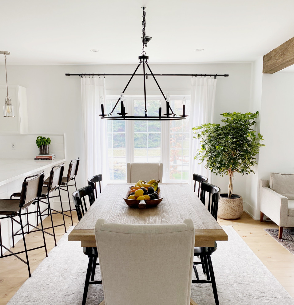 Immagine di una sala da pranzo aperta verso il soggiorno tradizionale di medie dimensioni con pareti bianche, parquet chiaro e pavimento beige
