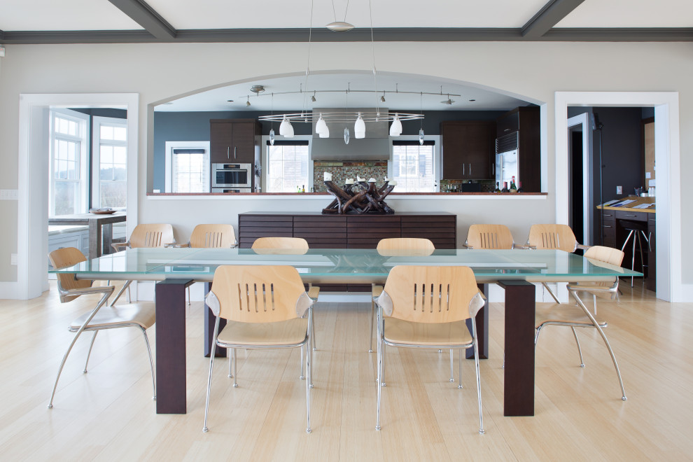 Immagine di una sala da pranzo aperta verso il soggiorno stile marinaro con parquet chiaro e nessun camino
