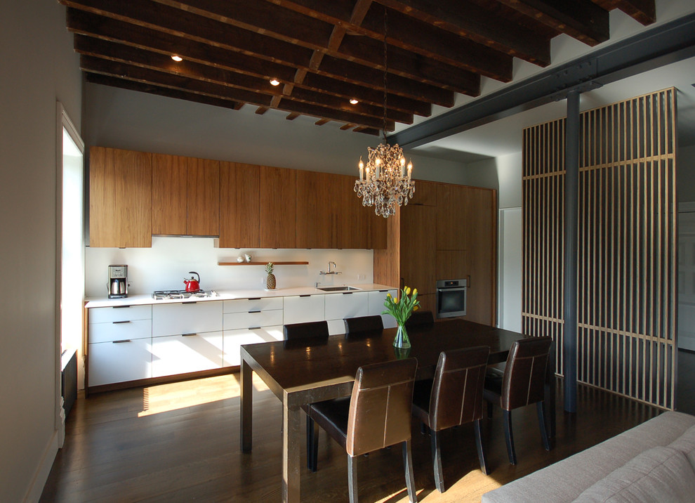 Inspiration pour une salle à manger ouverte sur le salon bohème de taille moyenne avec un mur gris, parquet foncé, une cheminée standard, un manteau de cheminée en carrelage et un sol marron.