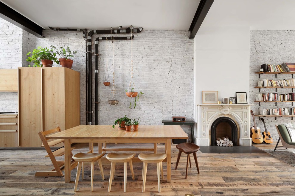 Cette image montre une salle à manger ouverte sur le salon urbaine avec un mur blanc, parquet foncé et un sol marron.