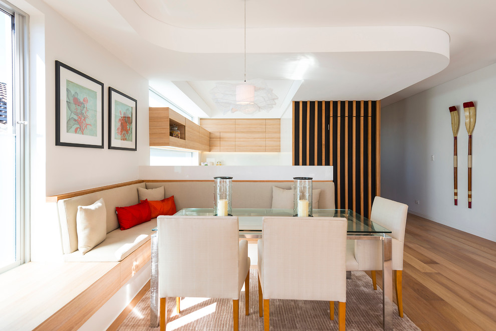 Immagine di una sala da pranzo aperta verso la cucina contemporanea di medie dimensioni con pareti bianche e nessun camino