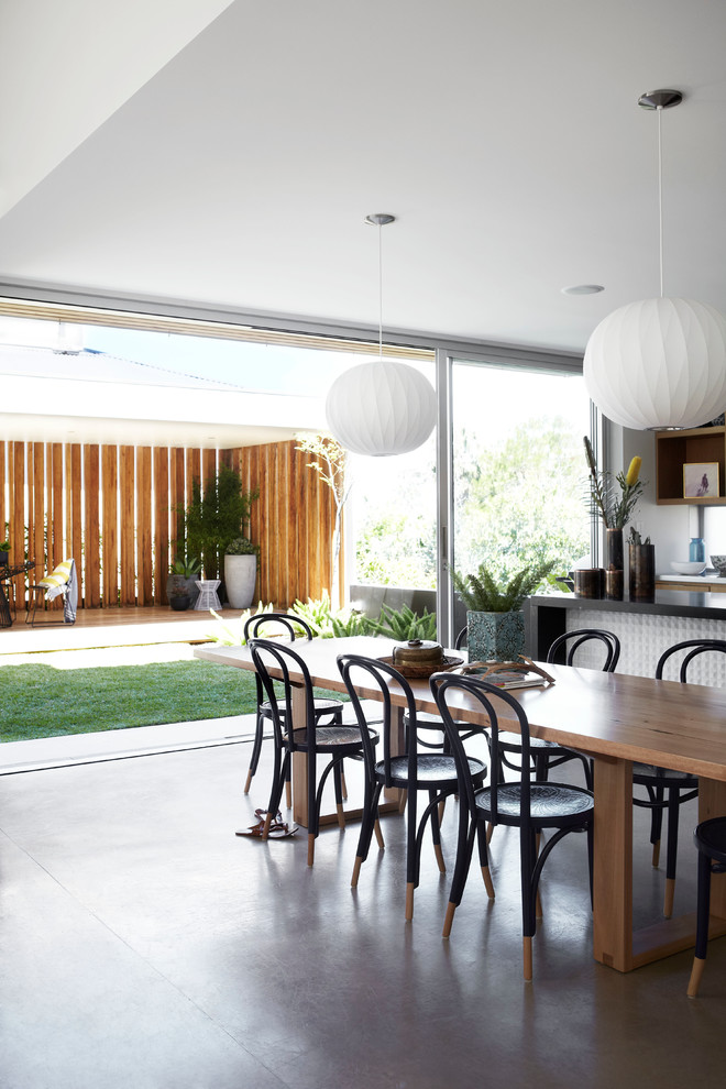 Пример оригинального дизайна: кухня-столовая среднего размера в современном стиле с бетонным полом и белыми стенами