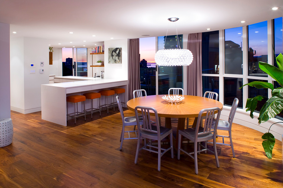 Esempio di una grande sala da pranzo aperta verso la cucina contemporanea con pavimento in legno massello medio e pareti bianche
