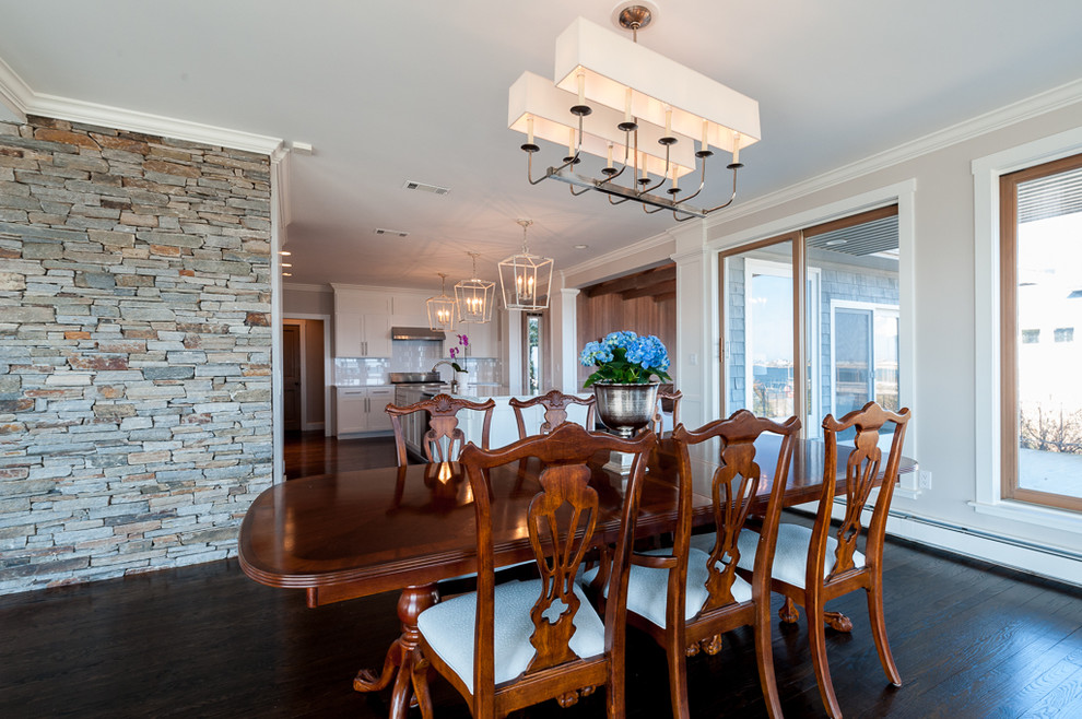 Foto di una grande sala da pranzo aperta verso la cucina eclettica con parquet scuro, pareti bianche e pavimento marrone