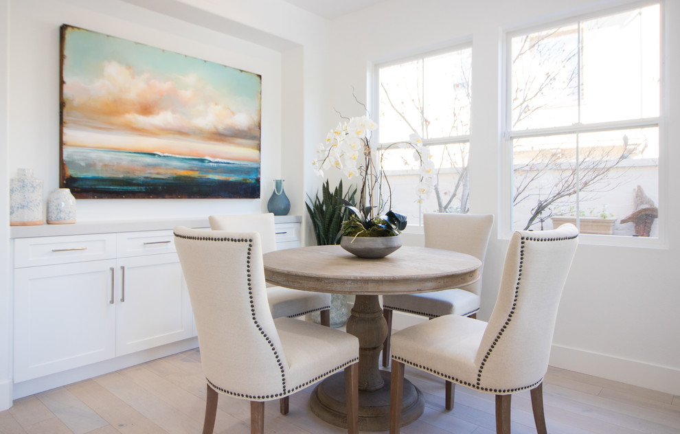 Idee per una sala da pranzo stile marino con pareti bianche, parquet chiaro e pavimento beige