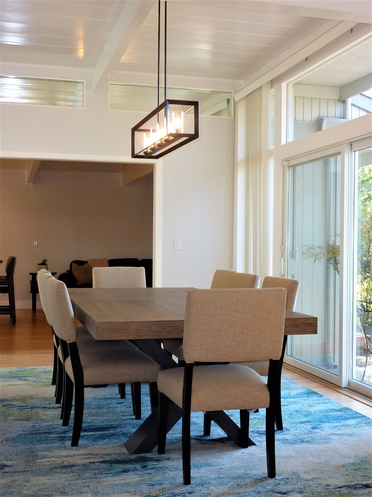 Cette photo montre une salle à manger ouverte sur le salon tendance de taille moyenne avec un mur gris et parquet clair.