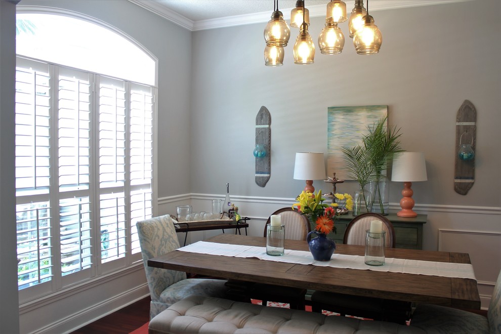 Example of a mid-sized beach style dark wood floor enclosed dining room design in New Orleans with gray walls and no fireplace