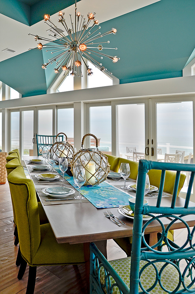 Esempio di un'ampia sala da pranzo aperta verso il soggiorno stile marinaro con pareti blu e parquet chiaro